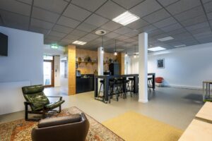 Moderne, open kantoorkeuken met zithoek aan de De Ruijterkade.